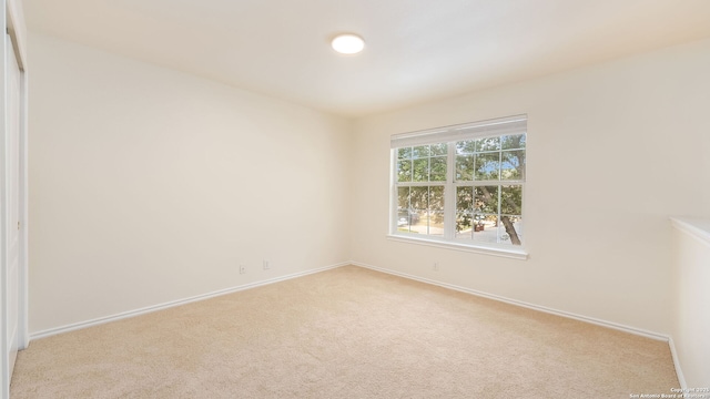 unfurnished room featuring light carpet