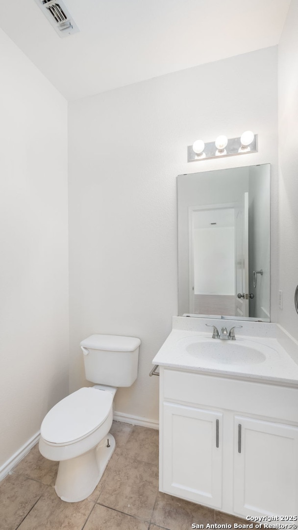 bathroom featuring tile patterned flooring, vanity, and toilet