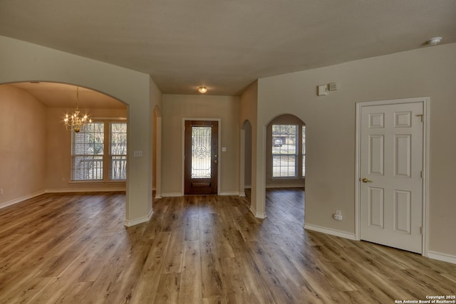 foyer entrance featuring a chandelier and wood-type flooring