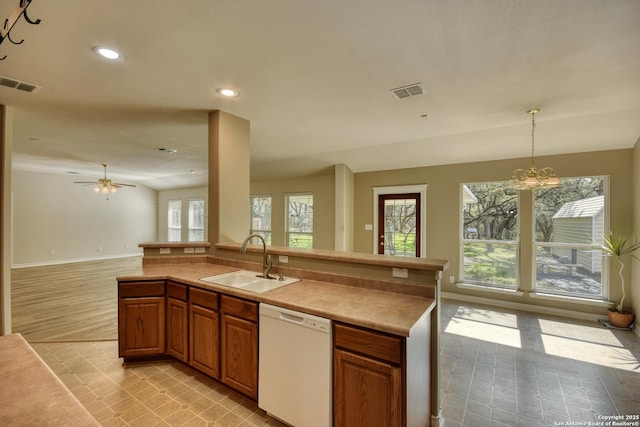 kitchen featuring sink, hanging light fixtures, white dishwasher, and ceiling fan with notable chandelier