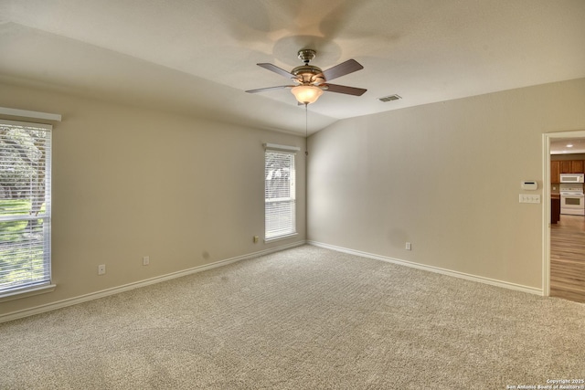 spare room with ceiling fan, carpet flooring, and vaulted ceiling