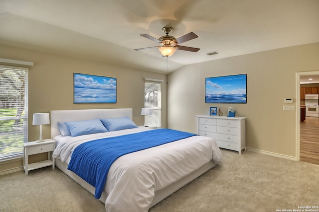 carpeted bedroom with ceiling fan and vaulted ceiling