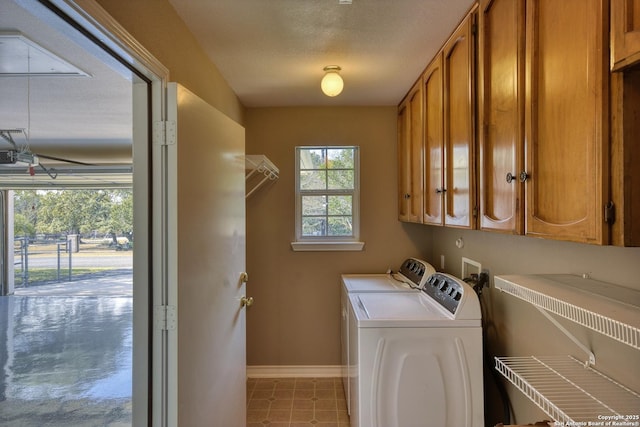 clothes washing area featuring cabinets, separate washer and dryer, and a textured ceiling