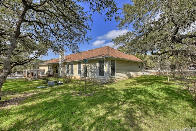 rear view of house featuring a lawn