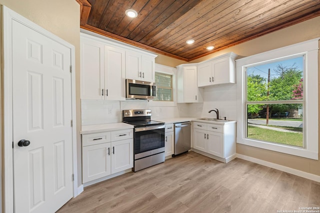 kitchen featuring appliances with stainless steel finishes, white cabinetry, sink, backsplash, and wooden ceiling