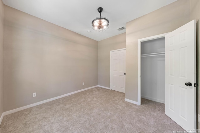 unfurnished bedroom with a closet and light carpet