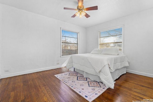 bedroom featuring multiple windows, dark hardwood / wood-style flooring, and ceiling fan