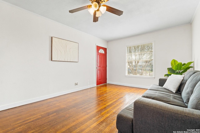 living room featuring hardwood / wood-style flooring, ornamental molding, and ceiling fan