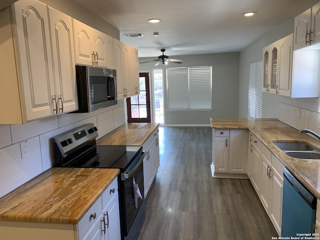 kitchen featuring dark hardwood / wood-style floors, sink, white cabinets, decorative backsplash, and stainless steel appliances