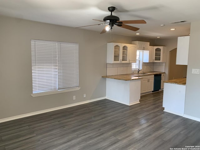 kitchen featuring tasteful backsplash, white cabinetry, dishwasher, and dark wood-type flooring