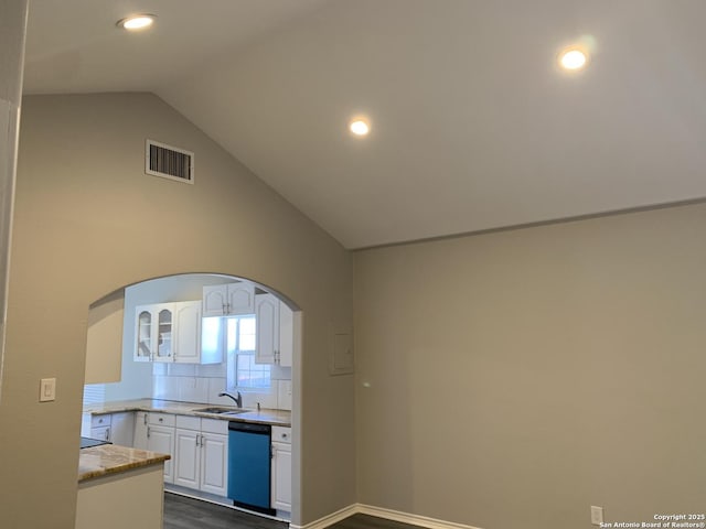 kitchen with lofted ceiling, black dishwasher, sink, white cabinets, and dark hardwood / wood-style flooring