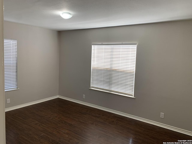 spare room with dark wood-type flooring