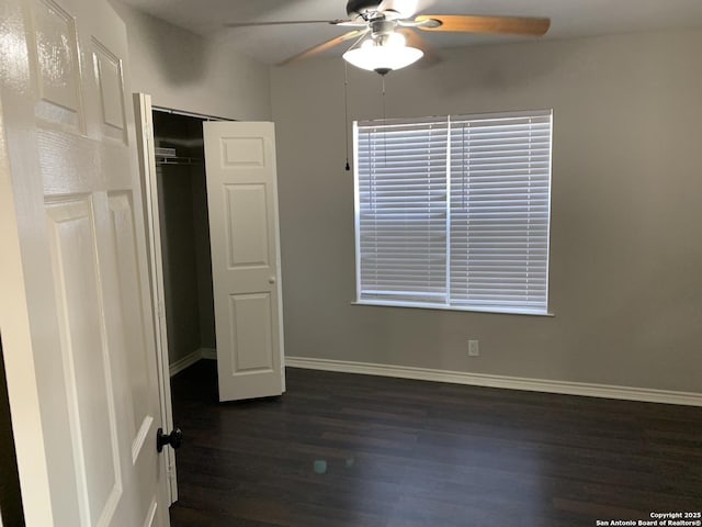 unfurnished bedroom with dark wood-type flooring, a closet, and ceiling fan