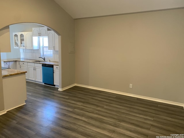 kitchen featuring sink, vaulted ceiling, dark hardwood / wood-style flooring, dishwasher, and white cabinets