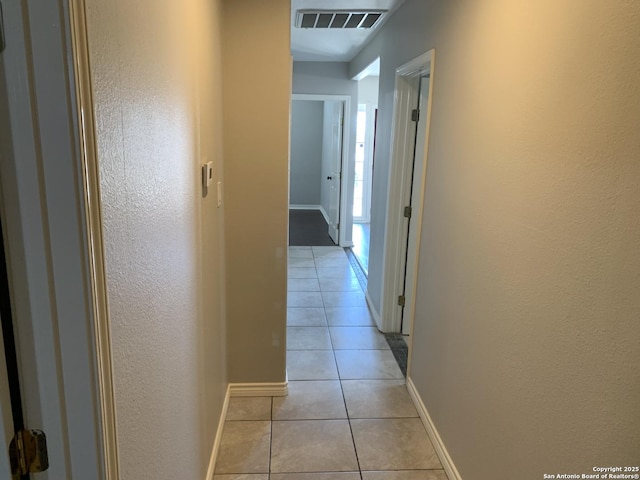 hall featuring light tile patterned flooring