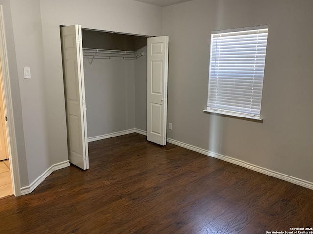 unfurnished bedroom featuring dark wood-type flooring and a closet