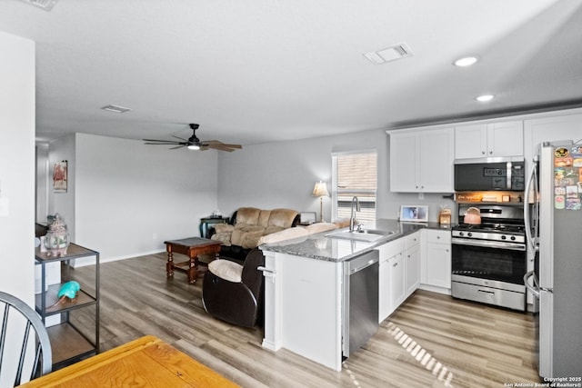 kitchen featuring sink, white cabinetry, kitchen peninsula, stainless steel appliances, and light hardwood / wood-style floors