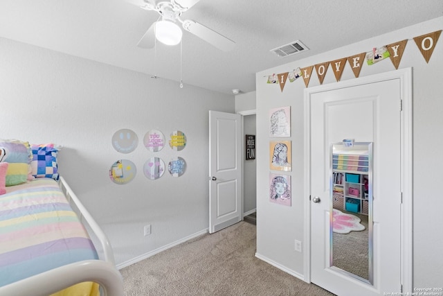 bedroom with light carpet, ceiling fan, and a textured ceiling