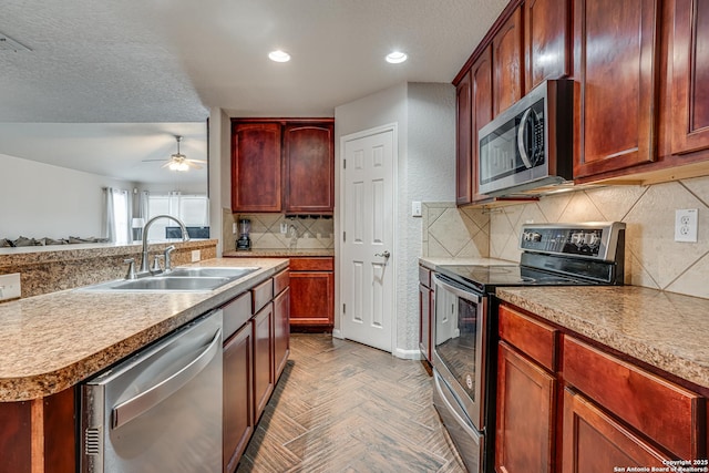 kitchen featuring sink, tasteful backsplash, a textured ceiling, parquet floors, and stainless steel appliances