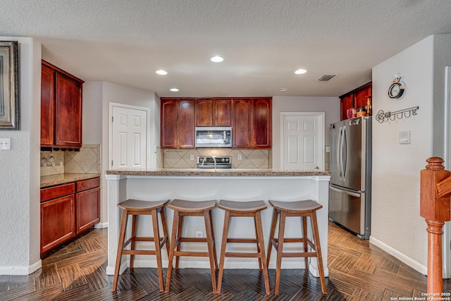 kitchen featuring stainless steel appliances, a center island, and a breakfast bar