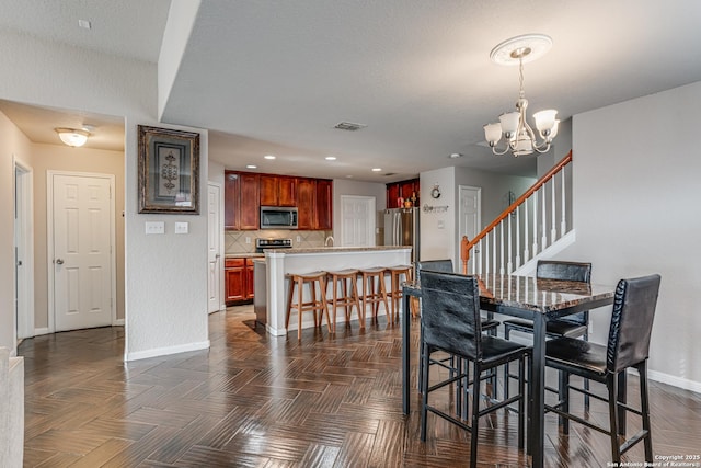 dining space with an inviting chandelier and dark parquet floors