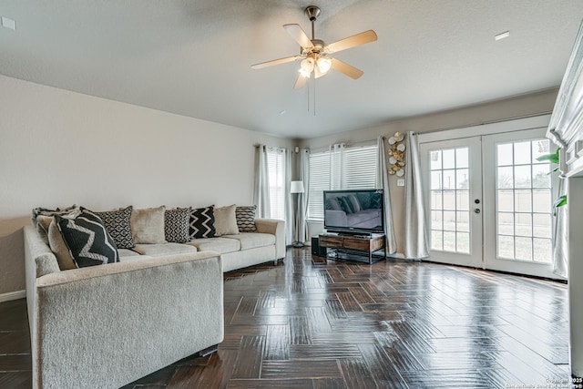 living room with dark parquet flooring, ceiling fan, and french doors