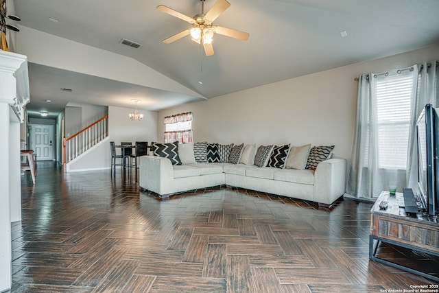 living room featuring ceiling fan with notable chandelier and vaulted ceiling