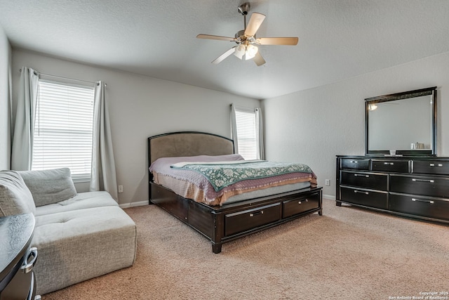 bedroom featuring light carpet, ceiling fan, and a textured ceiling