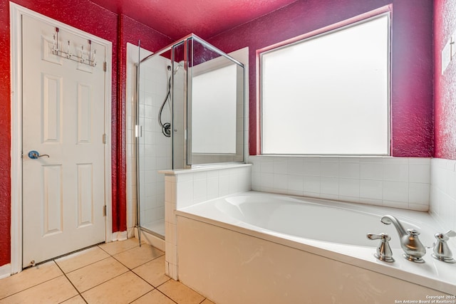 bathroom featuring tile patterned flooring and shower with separate bathtub