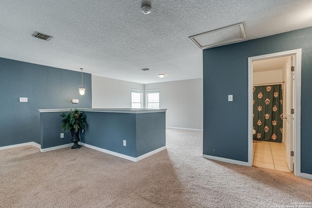 spare room featuring a textured ceiling and carpet