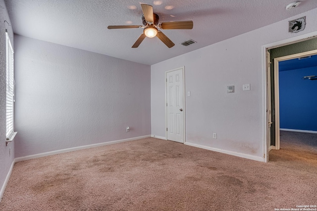 carpeted spare room featuring ceiling fan and a textured ceiling