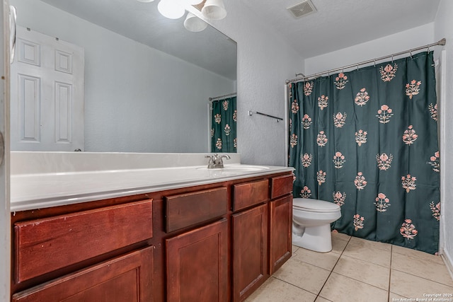 bathroom with tile patterned flooring, vanity, and toilet