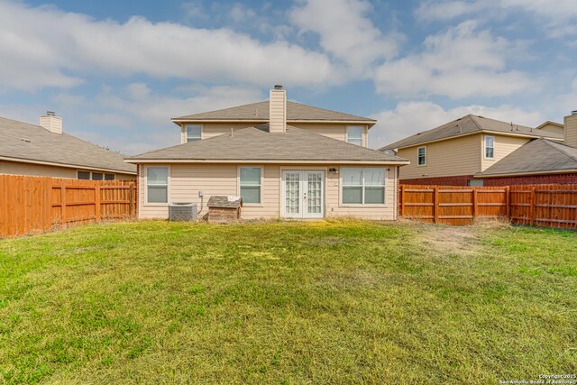 back of house with french doors, cooling unit, and a lawn