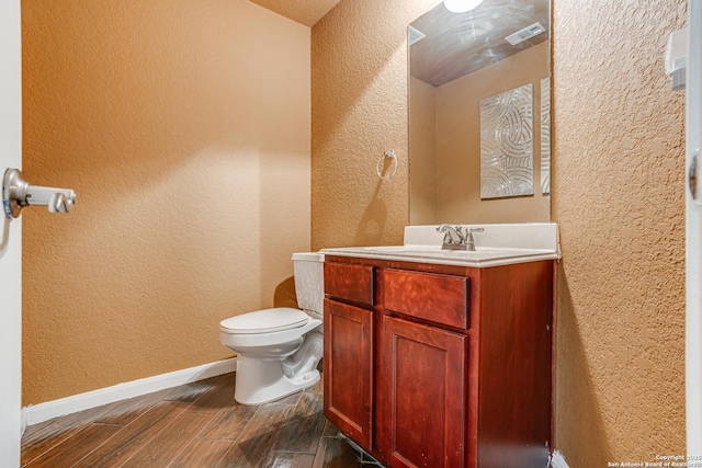 bathroom with vanity, hardwood / wood-style flooring, and toilet