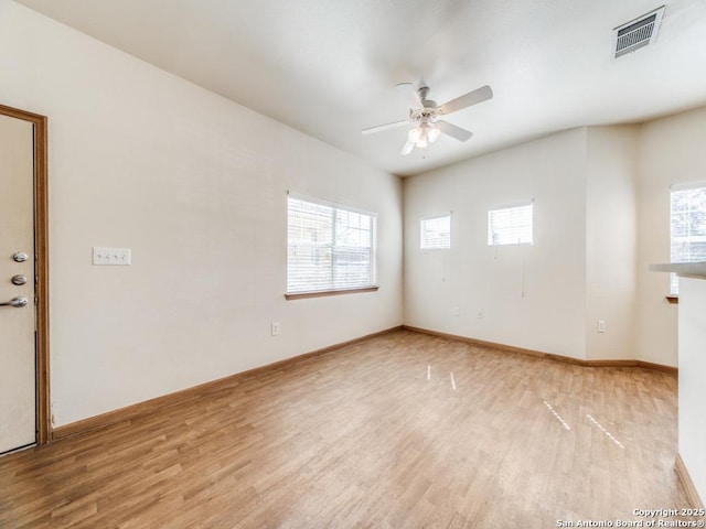 spare room with plenty of natural light, ceiling fan, and light hardwood / wood-style flooring