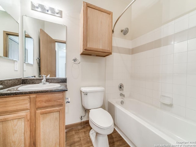 full bathroom with vanity, tiled shower / bath, wood-type flooring, and toilet