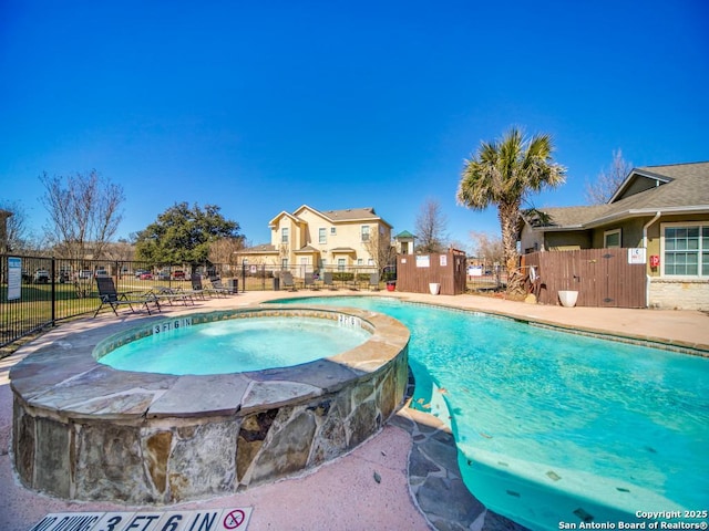 view of swimming pool featuring a hot tub