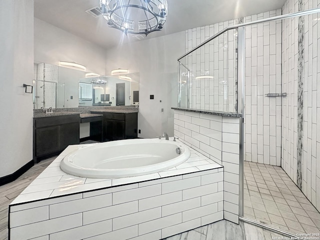 bathroom featuring vanity and independent shower and bath