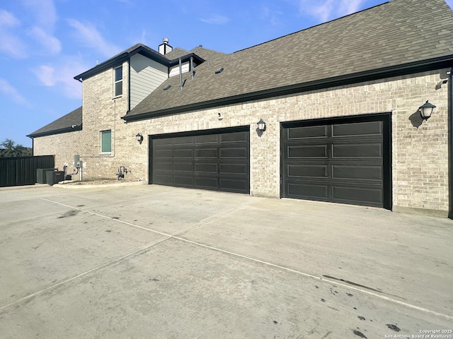 view of property exterior with a garage and central AC unit