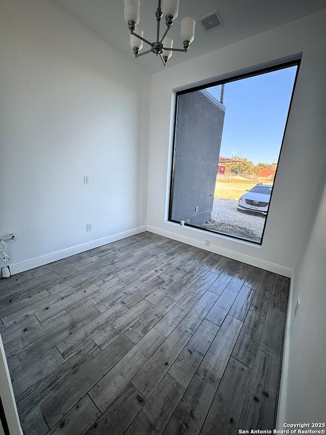 unfurnished room featuring wood-type flooring and a chandelier