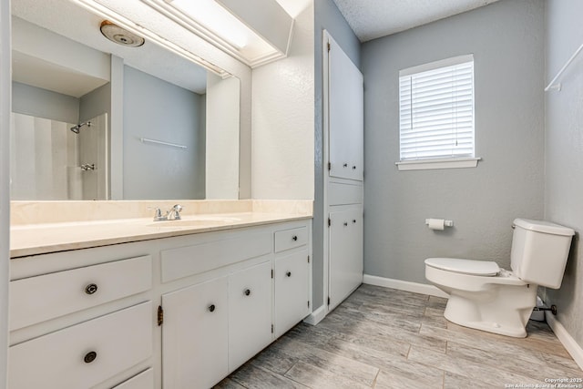 bathroom with walk in shower, vanity, toilet, and wood-type flooring