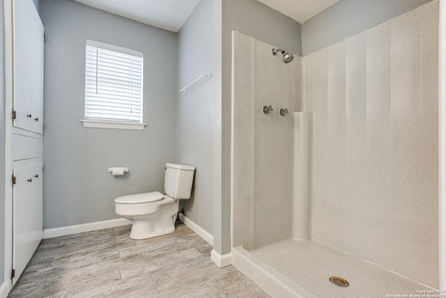 bathroom with a shower, hardwood / wood-style floors, and toilet