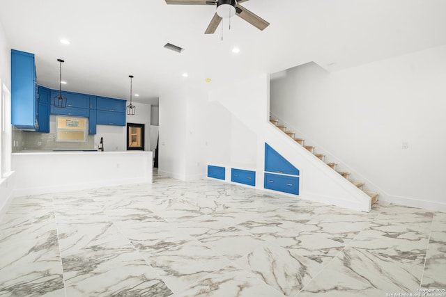 unfurnished living room featuring sink and ceiling fan