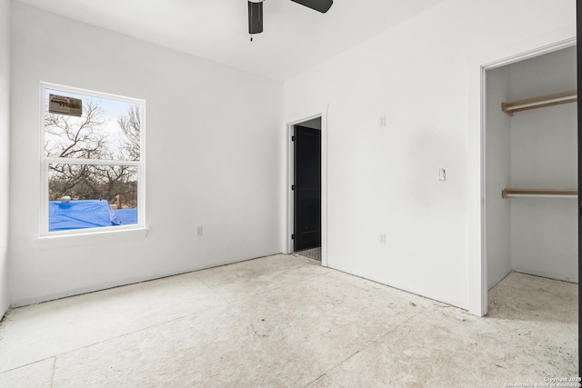 unfurnished bedroom with ceiling fan and a closet