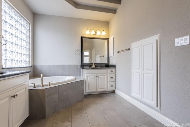 bathroom featuring tile patterned flooring, vanity, and a relaxing tiled tub