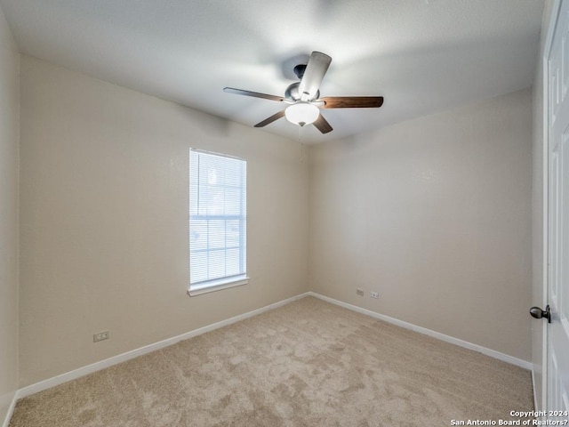 empty room featuring ceiling fan and light colored carpet