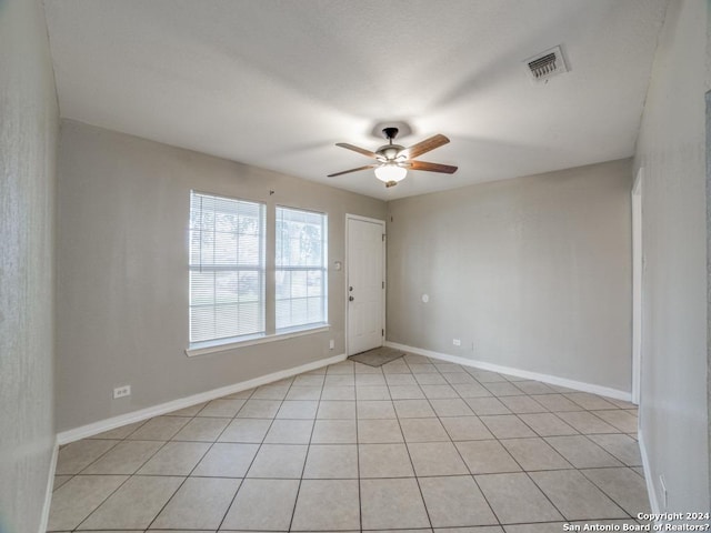 empty room featuring ceiling fan and light tile patterned floors