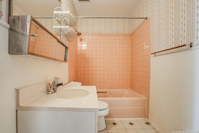 full bathroom with vanity, tiled shower / bath combo, tile patterned floors, and toilet