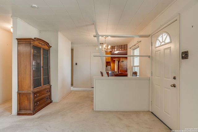 foyer featuring a notable chandelier, crown molding, and light colored carpet