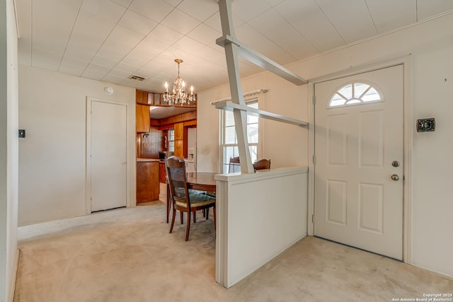 carpeted foyer featuring a chandelier